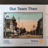 2 Image is of a cardboard box holding a puzzle. On the front it reads "our town then" and has the image of a lithograph postcard of King St., Dundas. It has the Dundas175 logo in the top left corner of the postcard.